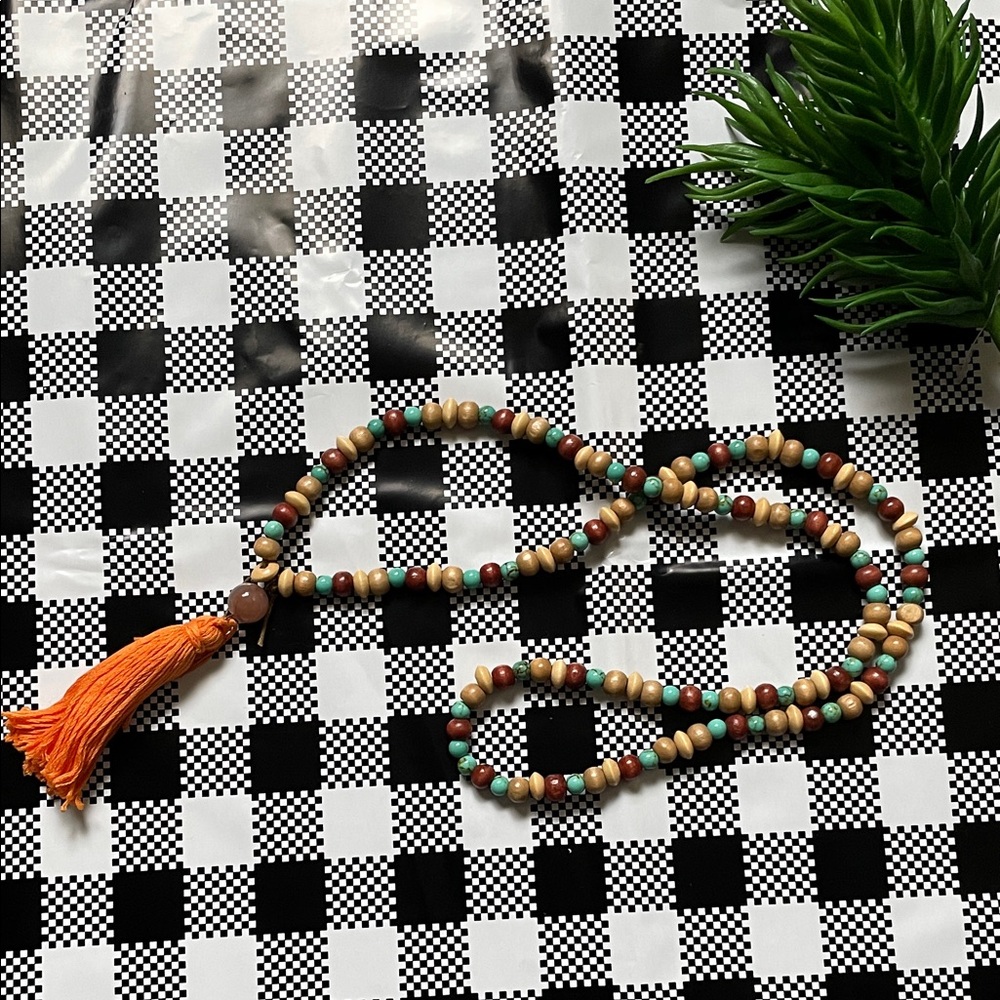 Hand assembled beaded necklace orange tassel
